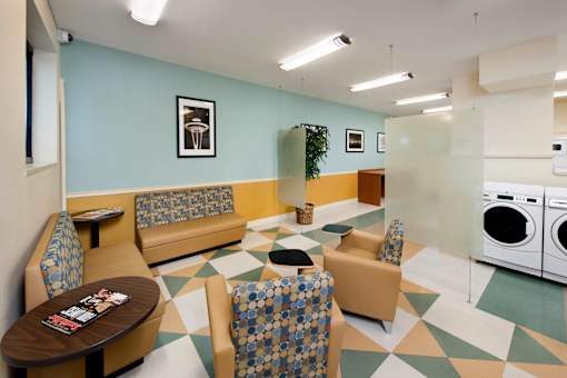 A laundry room with a washer and dryer, a table, and chairs at Skye at Belltown Apartments, Washington 98121