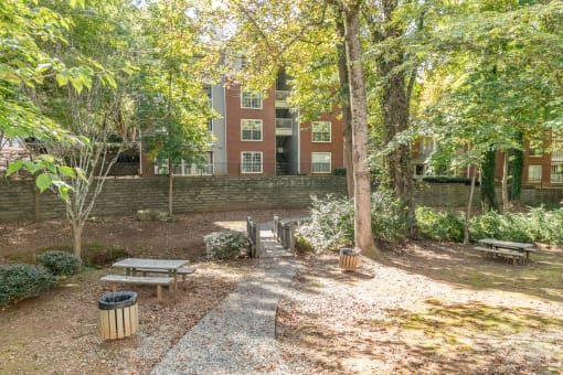 a courtyard with benches and trees in front of a brick building at Roswell Village, Georgia