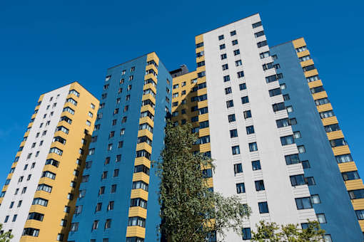 A tall building with a blue and yellow facade stands against a clear sky at Skye at Belltown Apartments, Washington