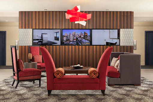 A modern living room with a large screen TV and comfortable seating at Skye at Belltown Apartments, Seattle, 98121