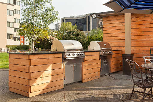 A wooden outdoor kitchen with a grill and sink at Skye at Belltown Apartments, Seattle, 98121
