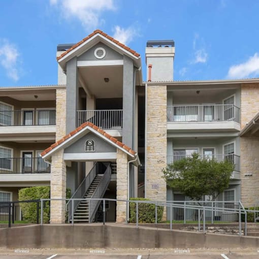 an apartment building with stairs and a stair case in front