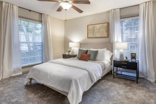 a bedroom with a bed and a ceiling fan at Roswell Village, Roswell