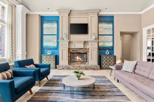 a living room with blue and white furniture and a fireplace at Villages of Cypress Creek, Houston, TX, 77070