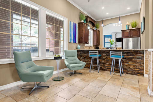 a living room with a kitchen with a bar and chairs at Villages of Cypress Creek, Houston