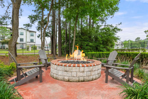 fire pit with chairs and a table and trees at Villages of Cypress Creek, Texas