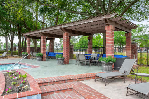 a gazebo with tables and chairs next to a swimming pool at Villages of Cypress Creek, Houston, TX, 77070