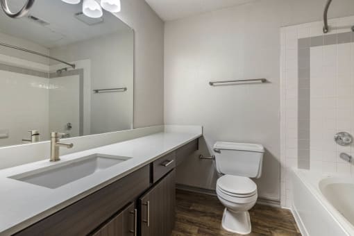a bathroom with a toilet and a sink and a mirror at Lakeshore at Preston, Texas