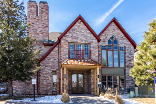 the front of a large brick building with snow on the ground  at The links at Plum Creek Apartments, Castlerock, CO 80104