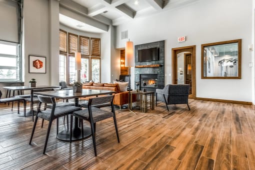 a living room with tables and chairs and a fireplace at The links at Plum Creek Apartments, Castlerock Colorado