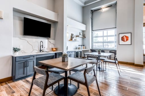 a dining room with a table and chairs and a kitchen with a tv at The links at Plum Creek Apartments, Castlerock Colorado