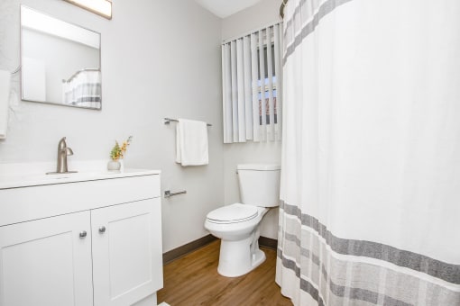 a bathroom with a shower and a toilet and a sink at MALA GROVE Apartments, Waipahu, HI