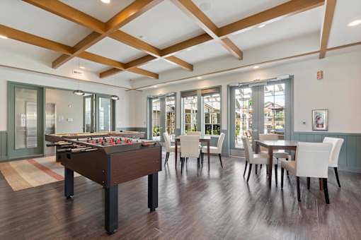 A room with a pool table and a dining table.