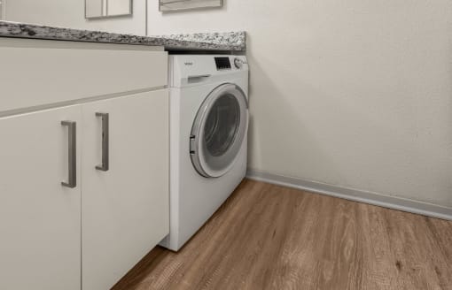 a front loading washer and dryer in a laundry room with a counter top at South Lamar Village, Texas