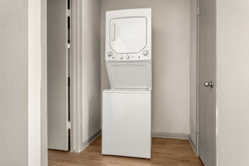 a white washer and dryer in a room with a door at South Lamar Village, Austin, TX