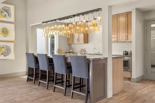 a kitchen with a bar with chairs and a chandelier at South Lamar Village, Texas, 78704