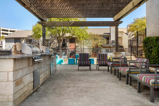 a outdoor patio with a grill and chairs at South Lamar Village, Austin, TX