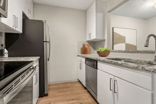 a kitchen with white cabinets and stainless steel appliances at South Lamar Village, Texas, 78704