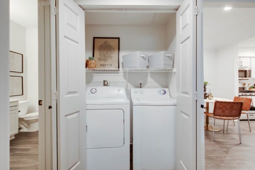 a washer and dryer in a white laundry room at The Olivine, Austin