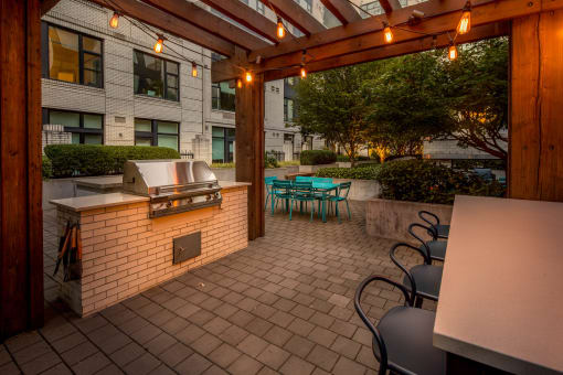 a patio with a grill and tables and chairs at The Parker Apartments, Portland, Oregon