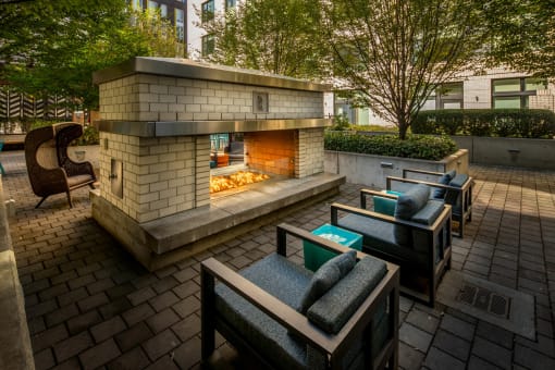 a patio with a fireplace and lounge chairs at The Parker Apartments, Portland, OR