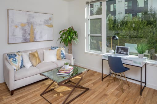 a living room with hardwood floors and a large window at The Parker Apartments, Portland