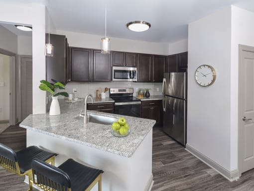 a kitchen with stainless steel appliances and a marble counter top at The Tribute, Raleigh