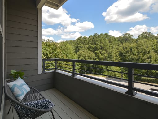 a balcony with a chair and a view of the woods at The Tribute, North Carolina, 27612