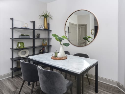 a dining room with a table and chairs and a mirror at The Tribute, Raleigh, NC