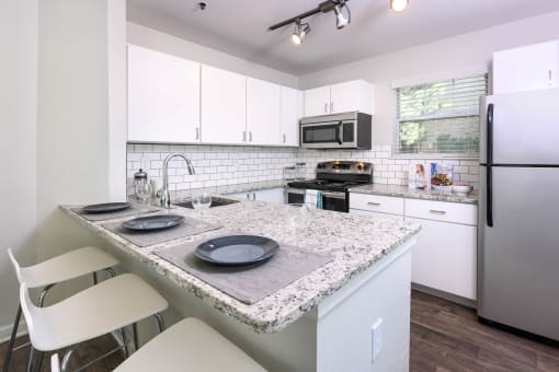 a kitchen with white cabinets and a granite counter top at Verdant, Colorado