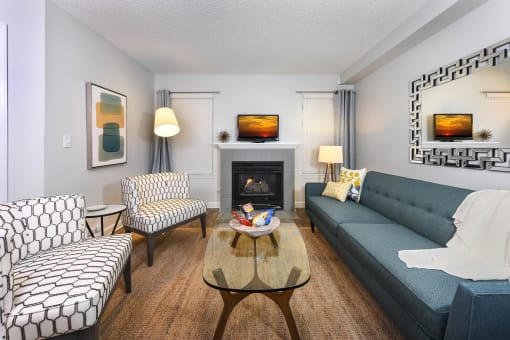 a living room with a blue couch and chairs and a fireplace at Verdant, Boulder, CO, 80303