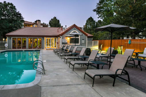 a pool with a row of lounge chairs next to a house at Verdant, Colorado