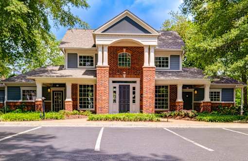 Clubhouse exterior with brick facade and white columns at Wyndchase Aspen Grove Apartments, Franklin