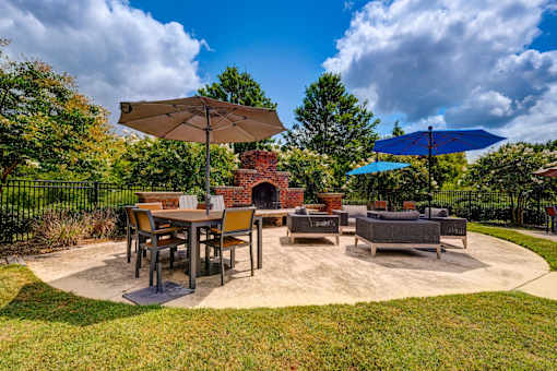 Outdoor patio with fireplace seating and dining area at Wyndchase Aspen Grove Apartments, Franklin, Tennessee