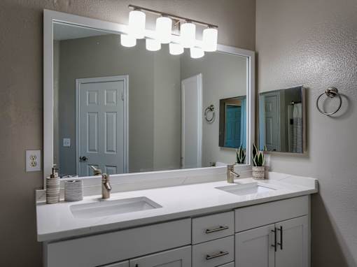 Double vanity bathroom with white countertop and mirror at Wyndchase Aspen Grove Apartments, Franklin, TN 37067