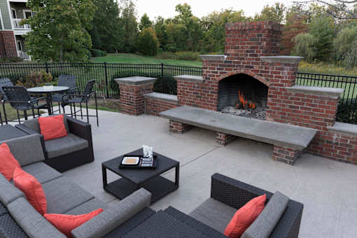 Brick outdoor fireplace with built in seating benches at Wyndchase Aspen Grove Apartments, Tennessee