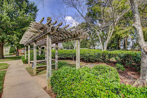 Wooden pergola with pathway and landscaped hedges at Wyndchase Aspen Grove Apartments, Tennessee