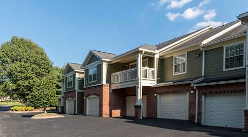 Two story apartment garages with balconies and brick accents at Wyndchase Aspen Grove Apartments, Franklin, 37067