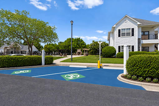 A parking lot with a blue painted area and a white building in the background.
