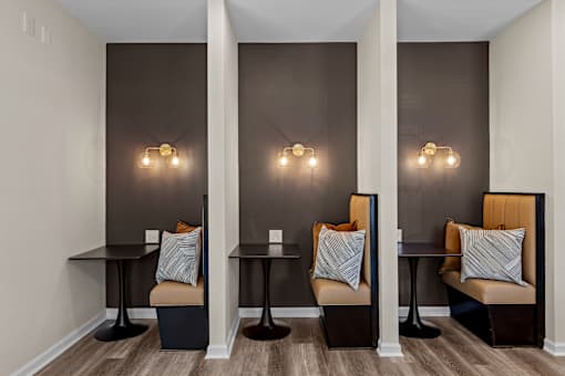 Three chairs with cushions and tables are placed in a room.