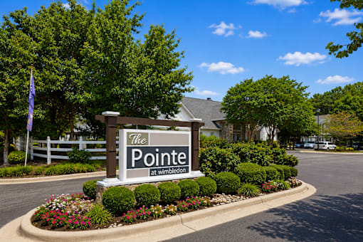 A sign that says "The Pointe at Wimbledon" in front of a building.