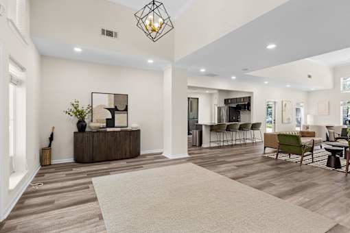 A modern living room with a white sofa, a wooden coffee table, and a large rug.