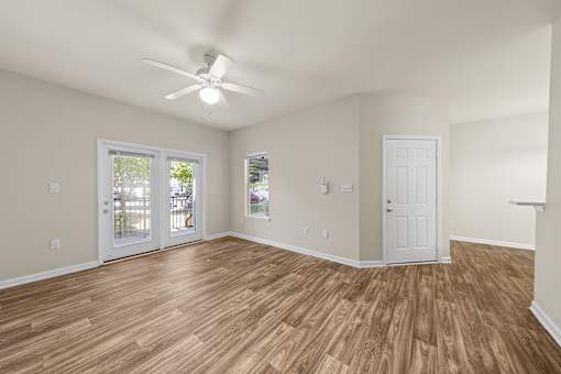 A room with a ceiling fan and wooden flooring.