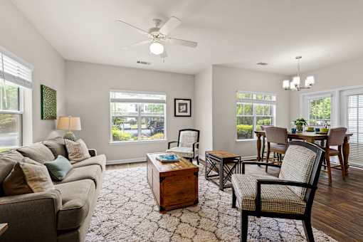 A living room with a grey couch, a coffee table, and a chair.