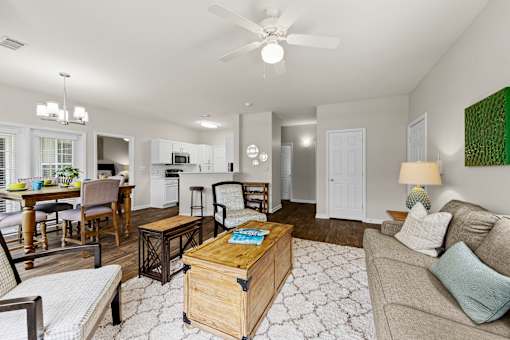 A living room with a couch, coffee table, and a ceiling fan.