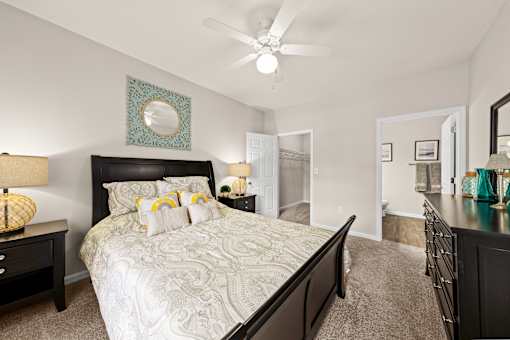 A bedroom with a large bed and a ceiling fan.