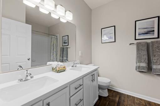 A bathroom with a white sink and a white toilet.