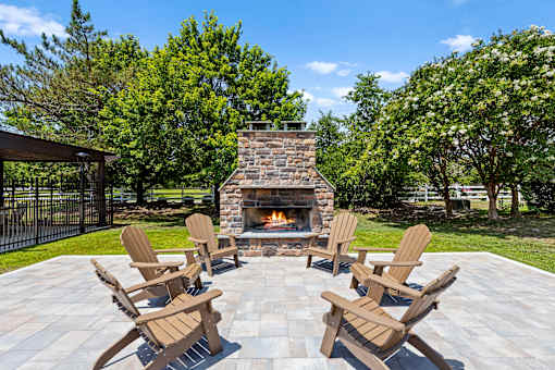 A set of four chairs are arranged around a fire place.
