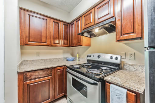 a kitchen with wood cabinets and granite counter tops and a stove top oven