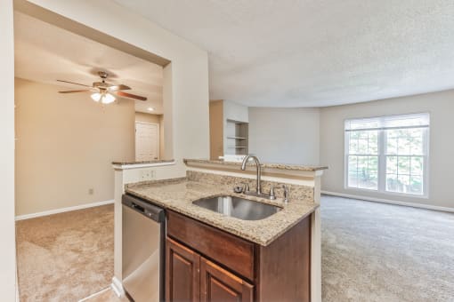 an empty kitchen with a sink and a ceiling fan